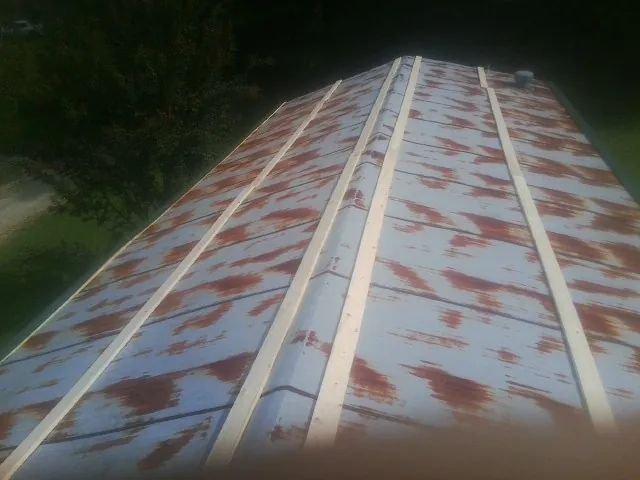 Rusted metal roof panels with new wood purlins before replacement — Storm Damage Roof Repair in Mchenry by Roofing Brothers
