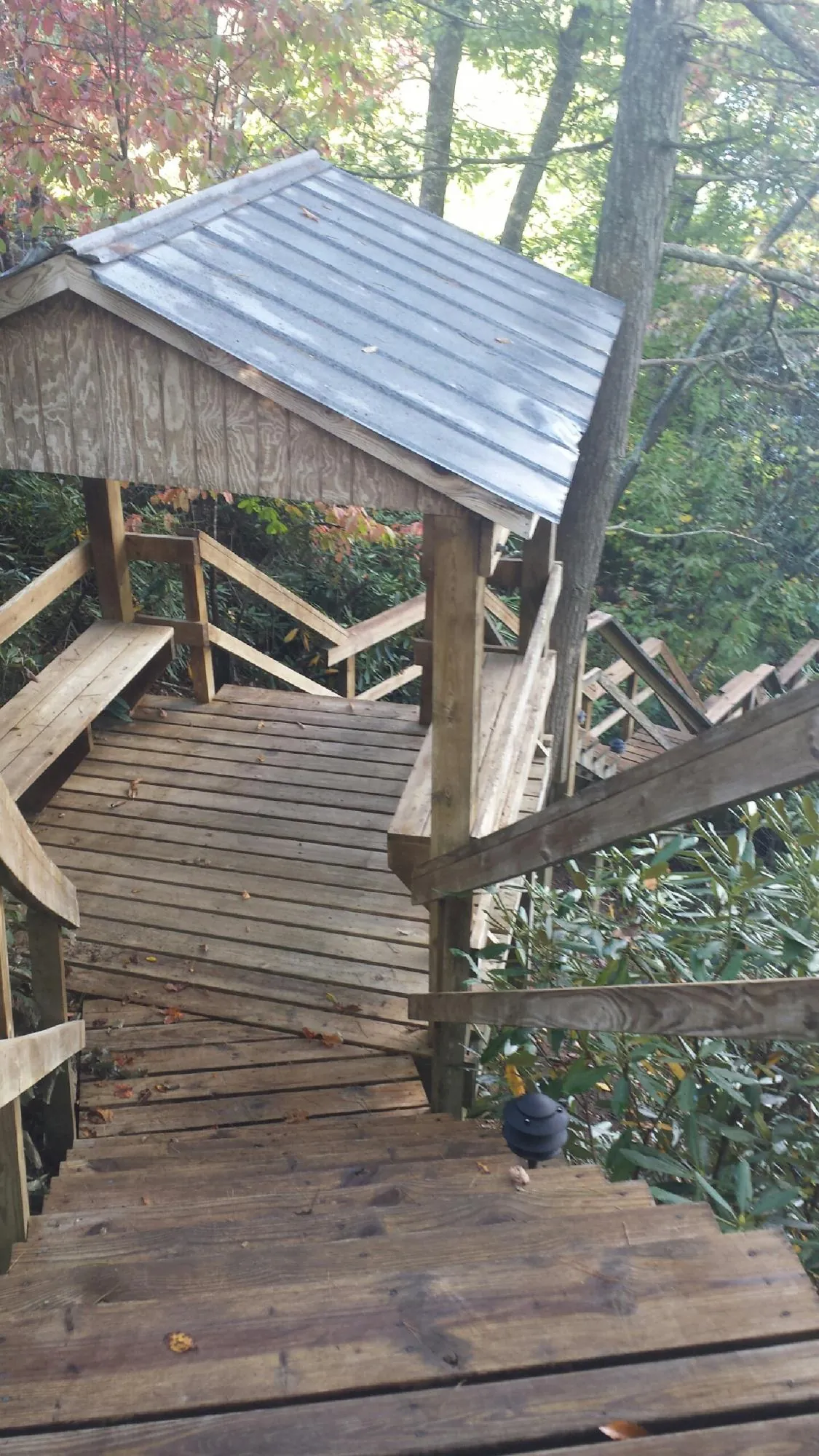 Metal roofed shelter over wooden steps on a wooded walkway — Skylight Repair & Installation work by our crew in Mchenry